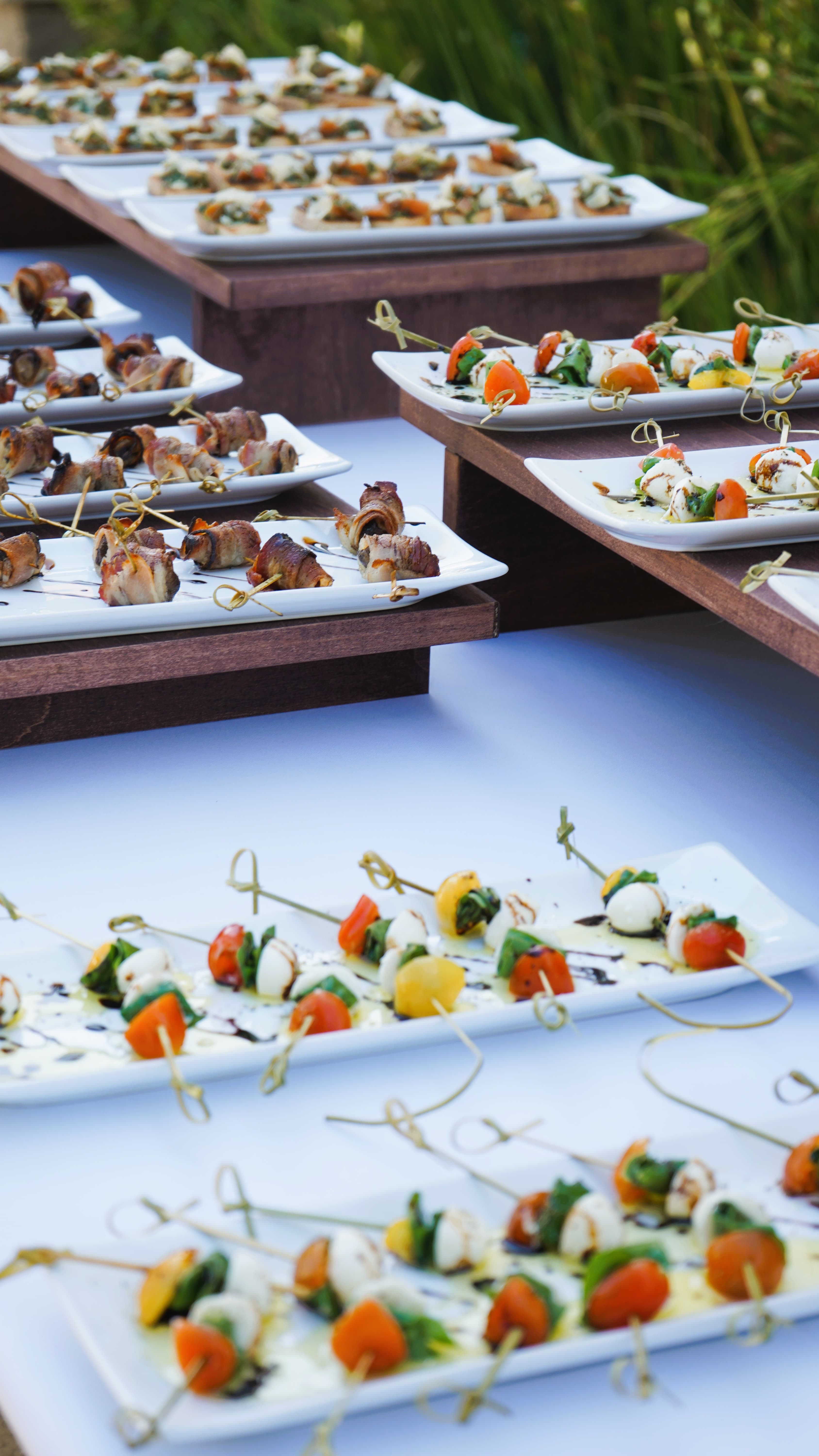 Caprese skewers, bruschetta, and bacon-wrapped bites on tiered platters