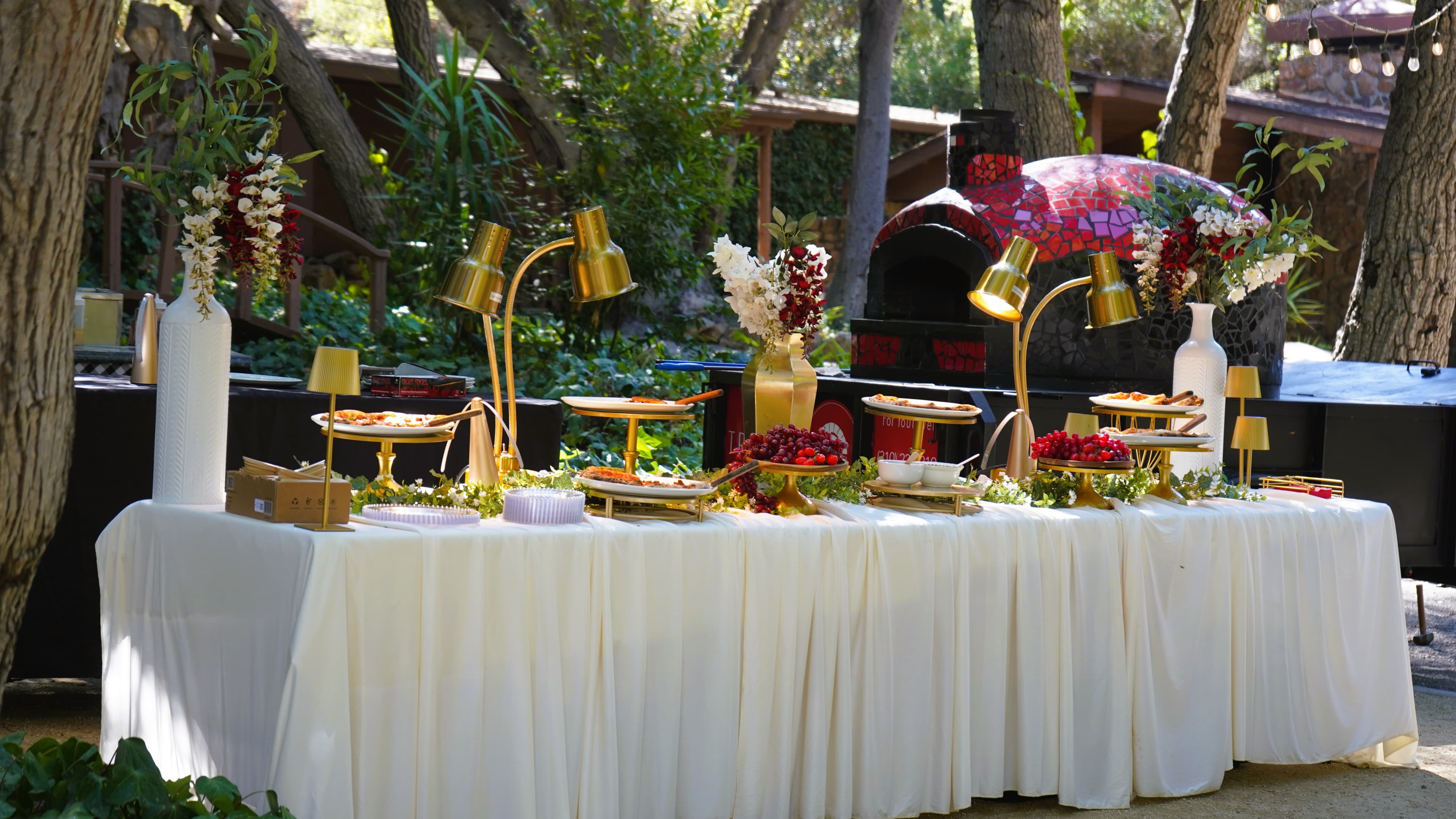 Wood-fired catering setup with oven and buffet
